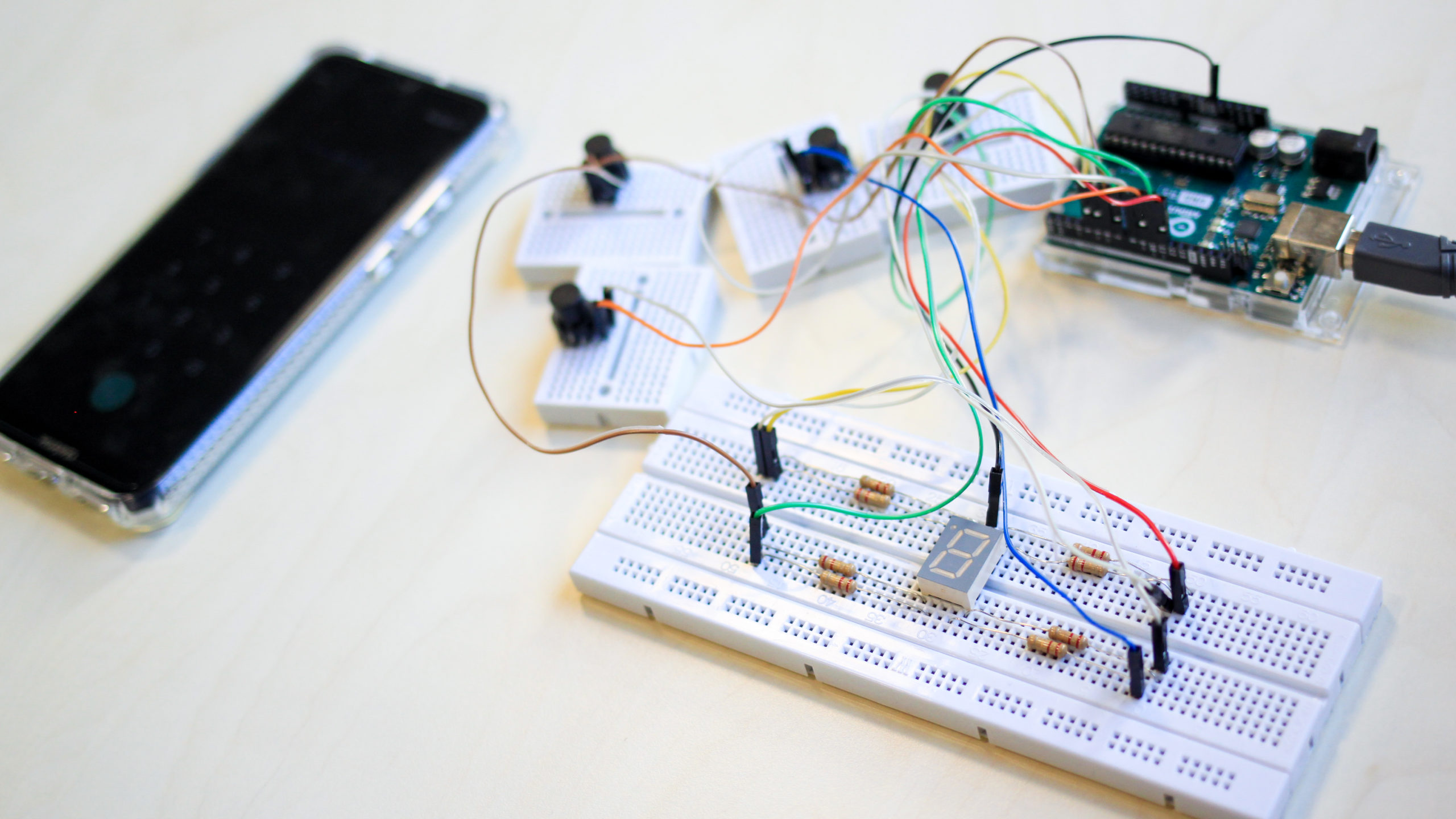 Photographie en gros plan d'un téléphone et d'un circuit électronique composé d'un cadran numérique et de boutons pressoirs.
